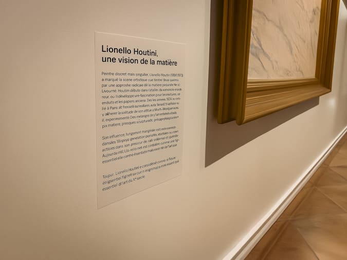 cartel de musée installé à côté d'une oeuvre