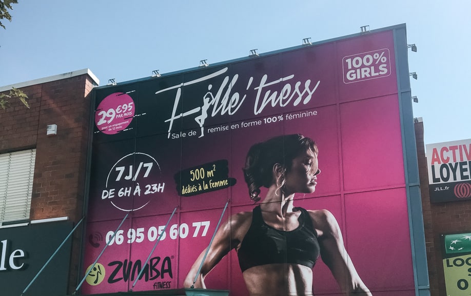 Vitrophanie design sur la façade vitrée de la salle de sport Fille’tness