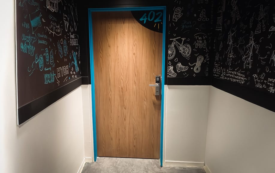 Numéro de chambre personnalisé fabriqué à Nantes sur porte en bois dans une résidence hôtelière