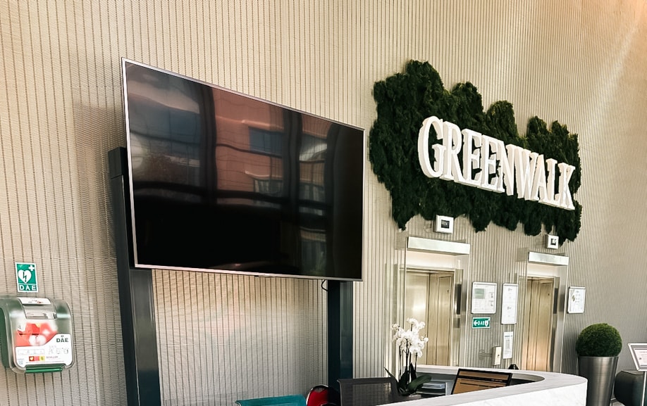 Accueil de bureaux rénové avec films décoratifs muraux et enseigne lumineuse intérieure.