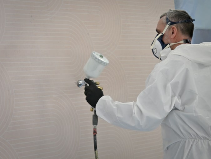 Application du vernis sur les tabliers de baignoire sur mesure imprimés par Graphitis