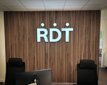 Mur d'accueil avec logo et signalétique aux couleurs de l'entreprise dans des bureaux à Nantes