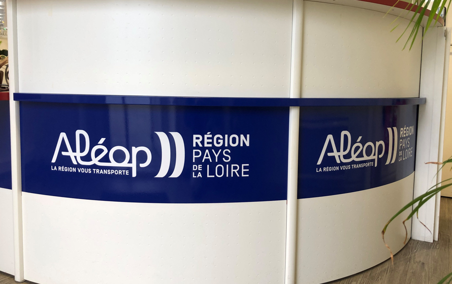 Pose d’une signalétique adhésive sur un mobilier d’accueil courbe